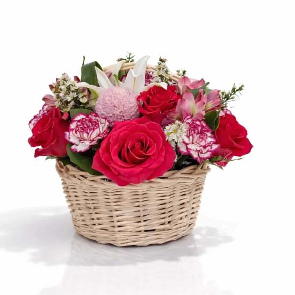 Basket of pink and red roses with white lilies and carnations
