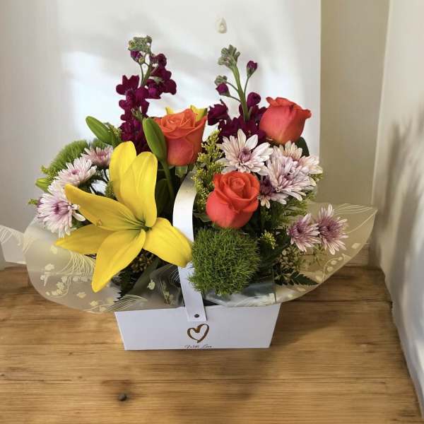 Mixed bouquet with roses, lilies, and daisies in a white gift box