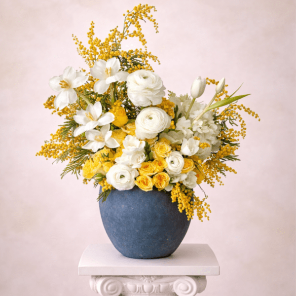 White and yellow flowers arranged in a blue vase