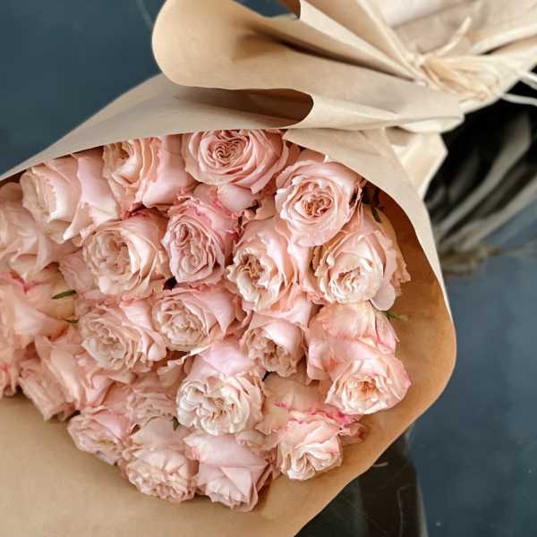 Bouquet of pale pink roses wrapped in beige paper