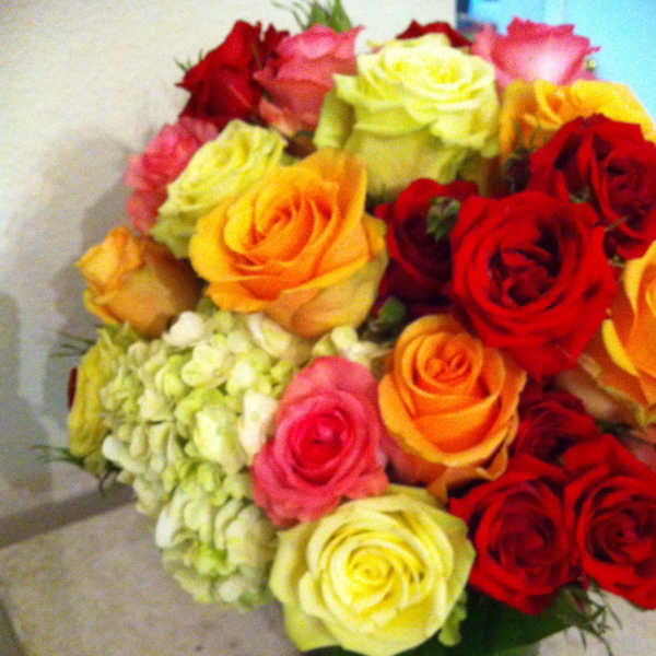 Bouquet of multicolored roses with pale hydrangea in a vase