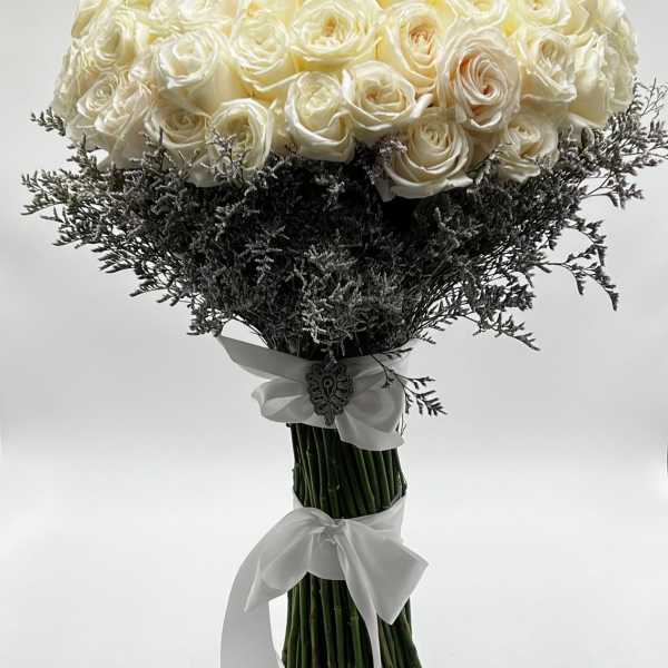 Bouquet of white roses with dark filler and white ribbon