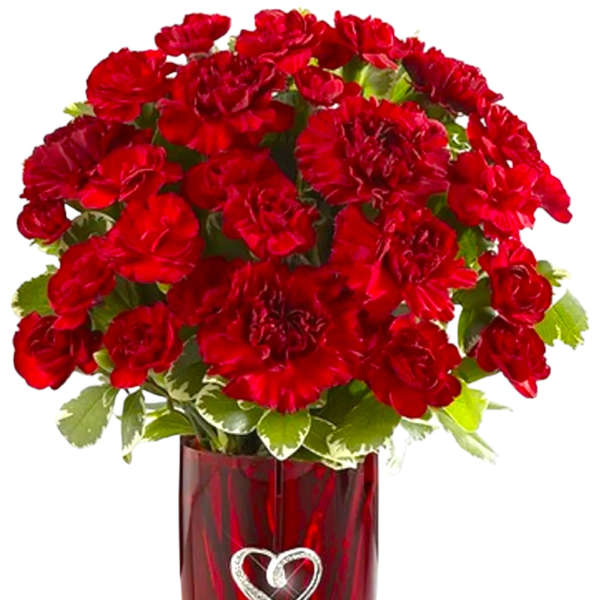 Red carnations in a red glass vase with a heart decoration