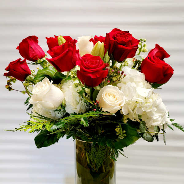 Red and white roses arranged in a tall glass vase