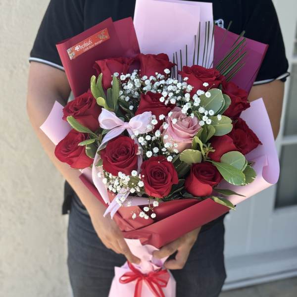 Bouquet of red and pink roses with baby's breath in pink wrapping