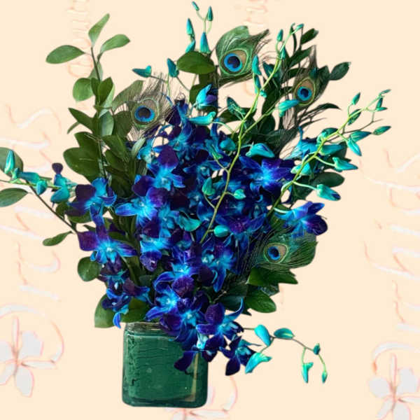 Blue orchids and peacock feathers in a green glass vase