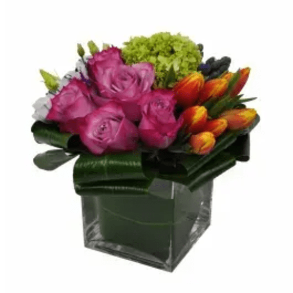Pink roses and orange tulips in a square glass vase