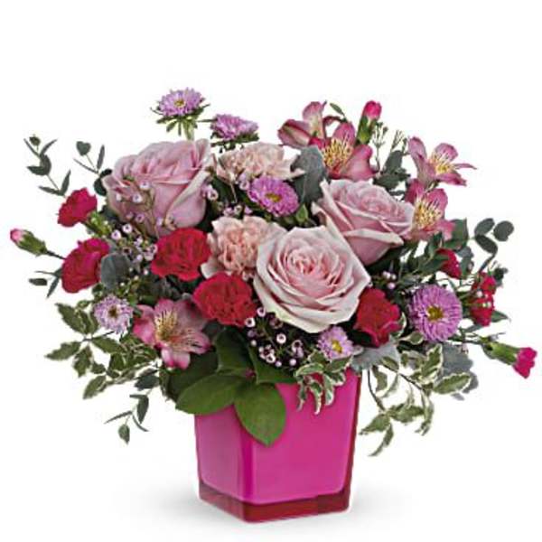 Pink and red mixed flower arrangement in a magenta vase