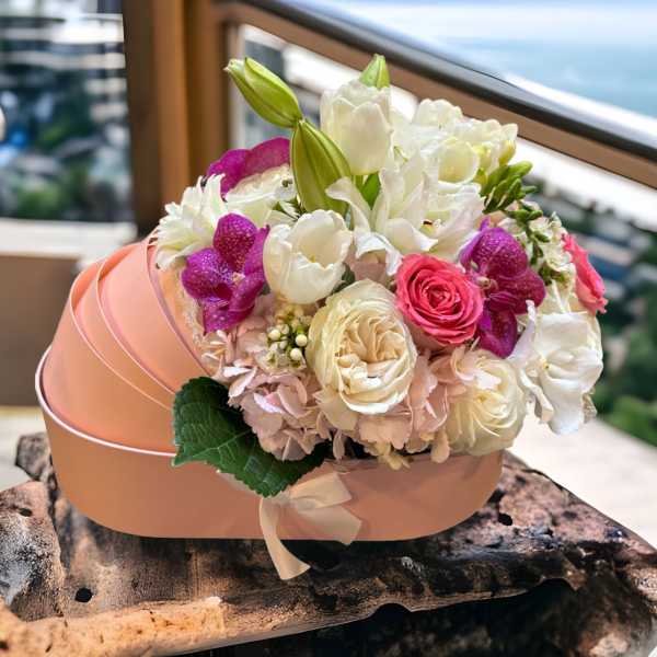 Pink and white bouquet in a round pink box with a ribbon