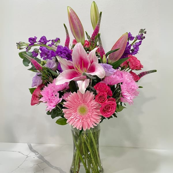 Pink and purple mixed bouquet in a clear glass vase