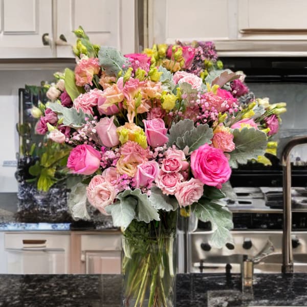 Large pink and peach bouquet in a clear glass vase