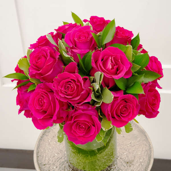 Bouquet of bright pink roses in a clear glass vase