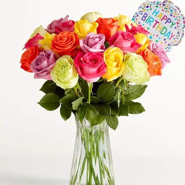 Colorful rose bouquet in a clear glass vase with a birthday balloon