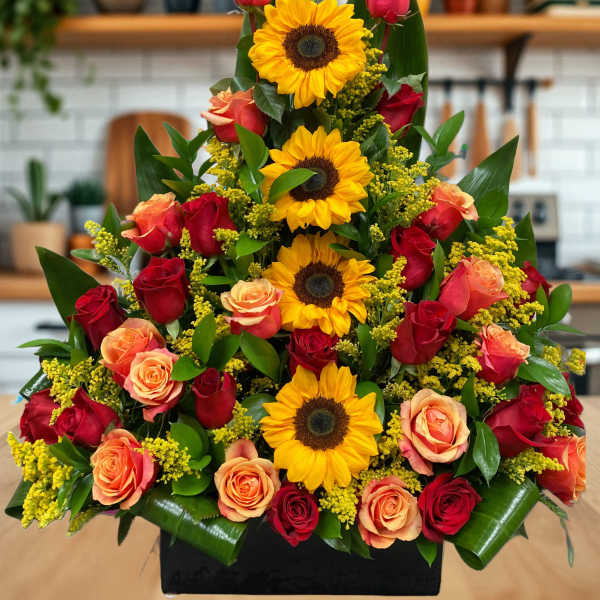 Tiered bouquet of red and peach roses with sunflowers in a black container