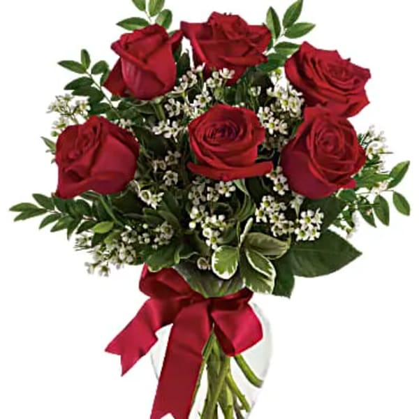 Bouquet of red roses with white filler flowers in a glass vase