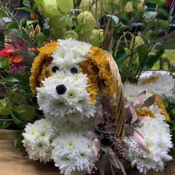 Flower arrangement shaped like a dog in a basket