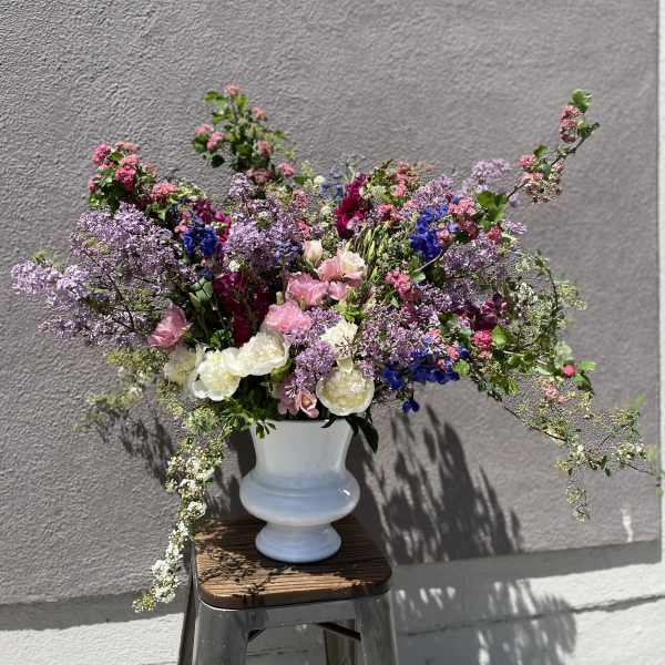 Large mixed bouquet in a white vase with pink, purple, and white flowers