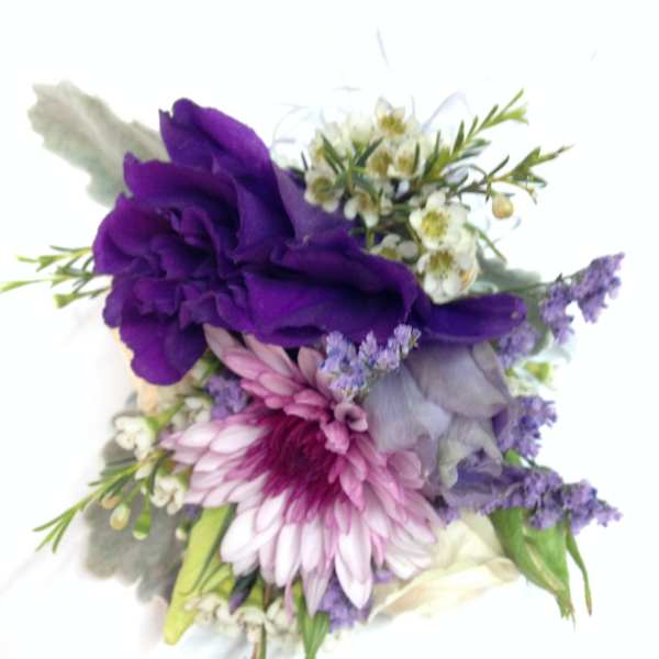Purple and pink floral corsage with small white blossoms