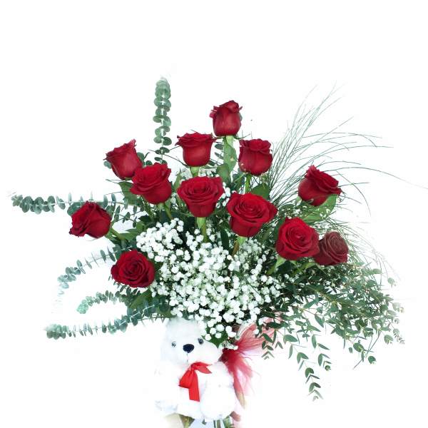 Red roses in a glass vase with a teddy bear attached