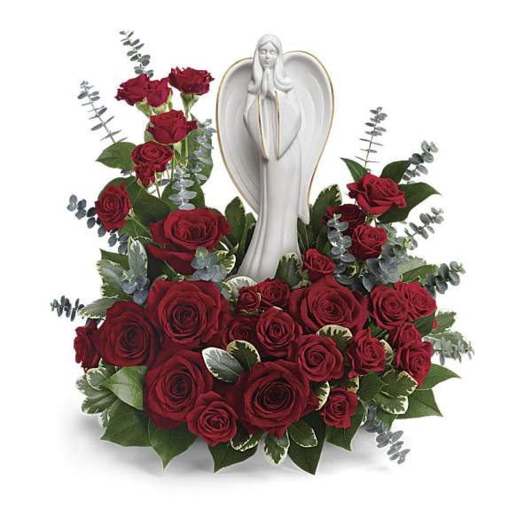 Red roses arranged around a white angel statue