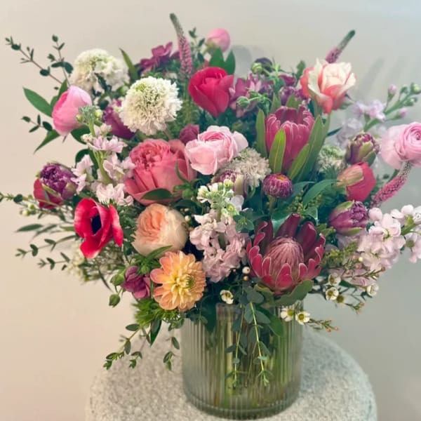 Mixed pink and white floral arrangement in a ribbed glass vase