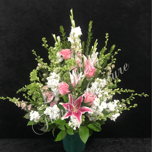 Pink roses and a lily in a vase with white flowers