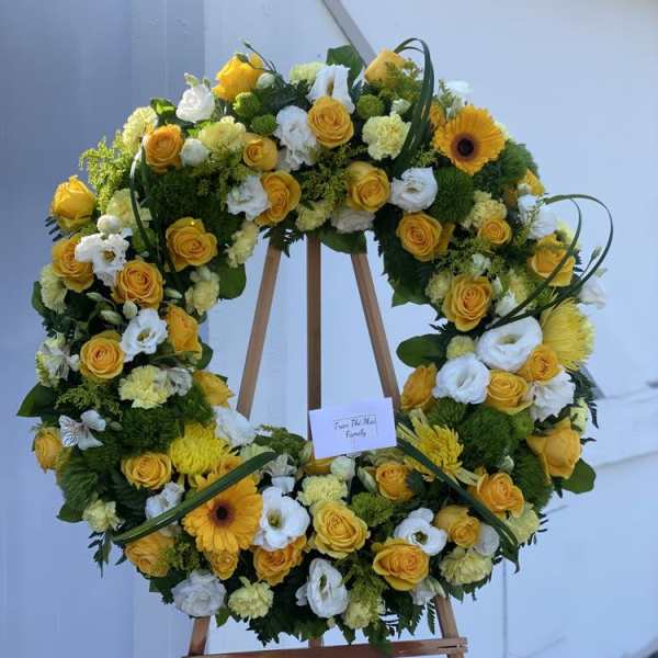 Yellow and white floral wreath on a wooden easel