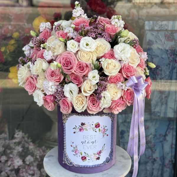 Pink and white rose bouquet in a purple hatbox with a ribbon