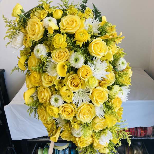 Large yellow and white floral spray with roses and daisies