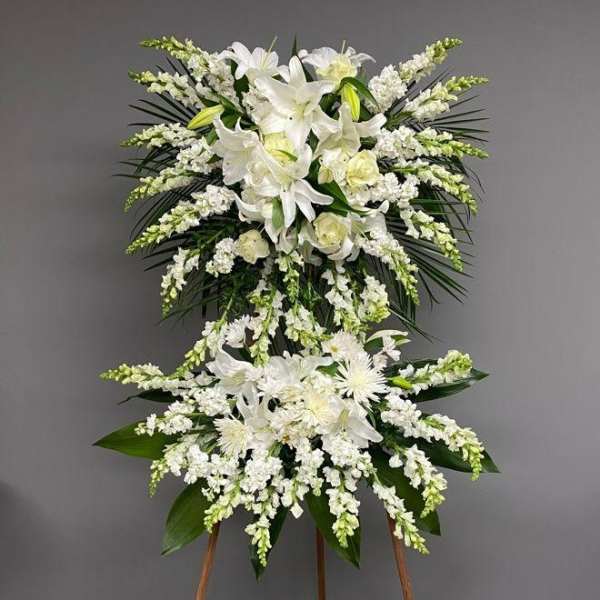 White floral standing spray on an easel