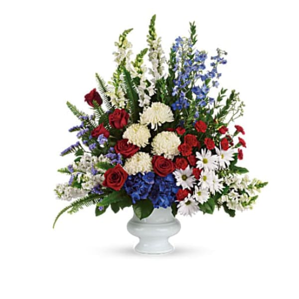 Mixed red, white, and blue flowers arranged in a white vase