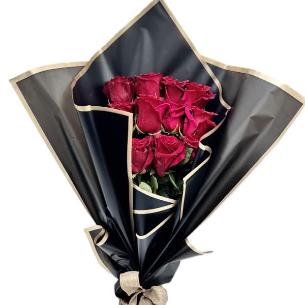 Bouquet of red roses wrapped in black paper with a beige ribbon bow