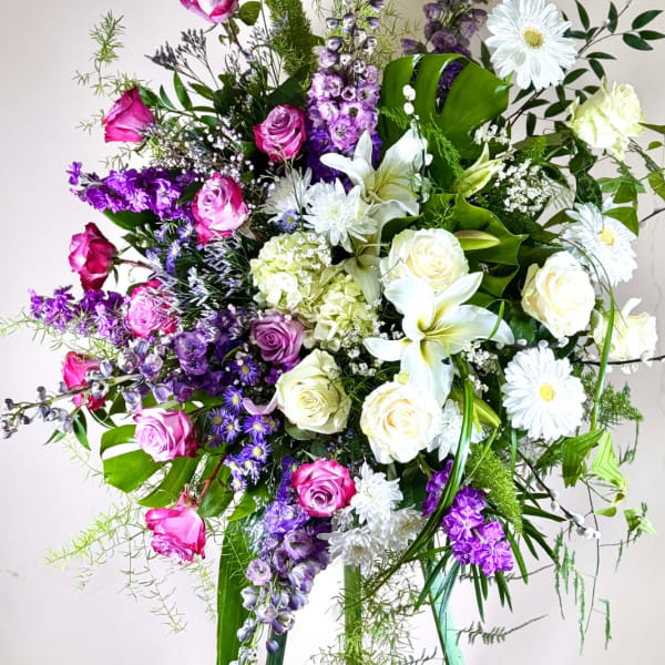 Tall mixed bouquet with pink and white roses, lilies, and purple flowers