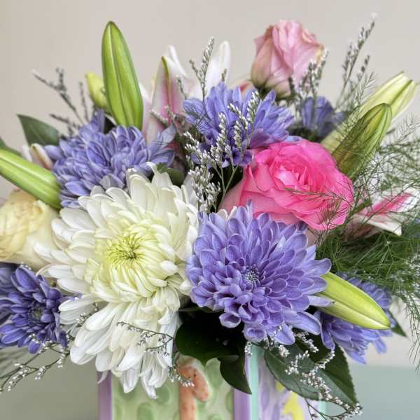 Bouquet of pink, white, and purple flowers in a decorated vase