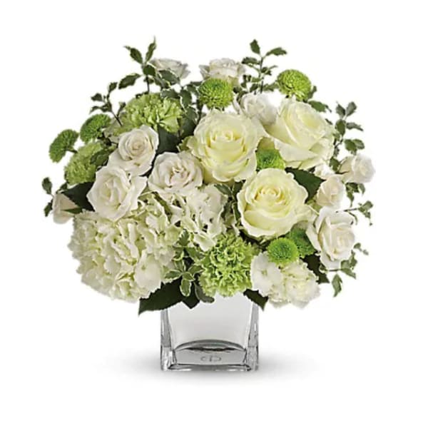 White roses and green pompons in a clear square vase