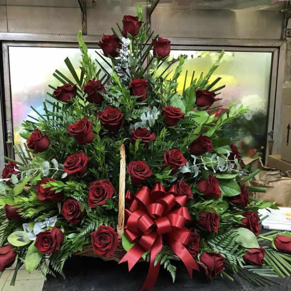 Basket arrangement of red roses with a large red ribbon bow