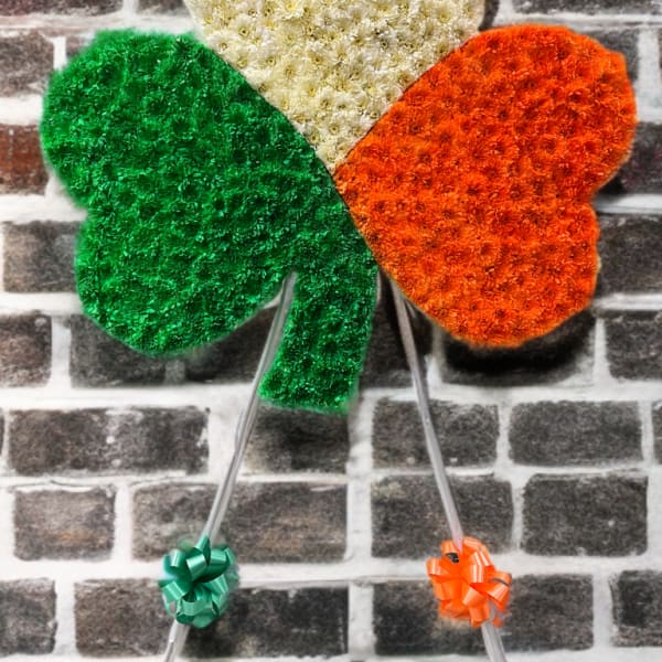 Three heart-shaped floral panels in green, white, and orange on stands