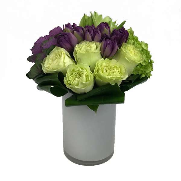 Purple and green bouquet in a white vase
