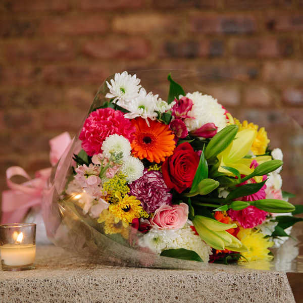 Mixed bouquet of colorful flowers wrapped in clear plastic