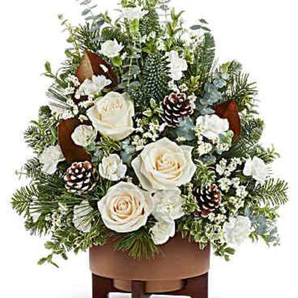 White roses and pinecones in a brown container with evergreen accents