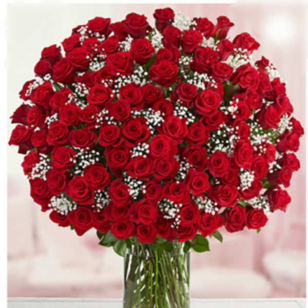 Large bouquet of red roses with baby's breath in a clear glass vase