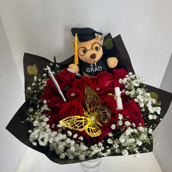 Red rose bouquet with baby’s breath and a graduation teddy bear topper