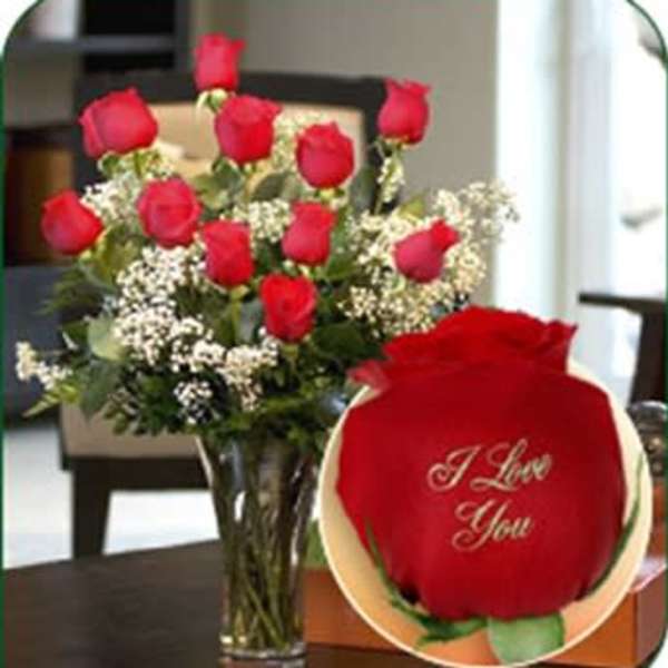 Bouquet of red roses in a glass vase with a single rose gift box