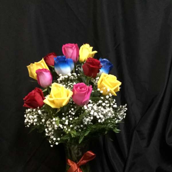 Bouquet of multicolored roses in a glass vase with baby's breath