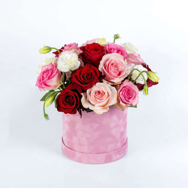 Pink and red roses arranged in a pink round box