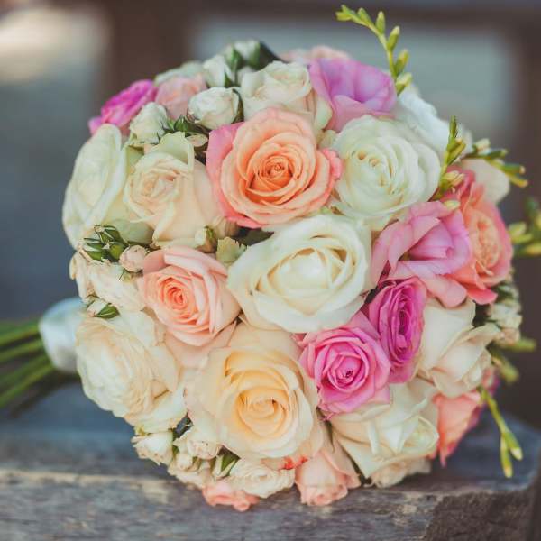 Bouquet of pastel roses in cream, pink, and peach