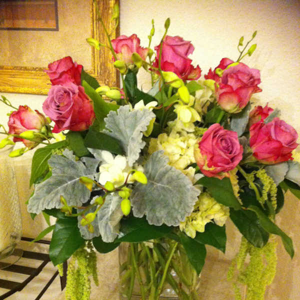 Pink roses and white flowers arranged in a clear glass vase