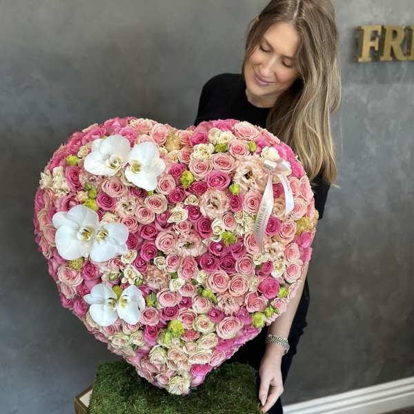 Heart-shaped bouquet of pink and white roses with white orchids
