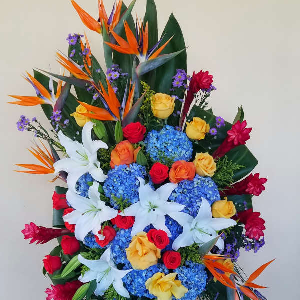 Tall standing floral spray with lilies, roses, hydrangeas, and bird-of-paradise