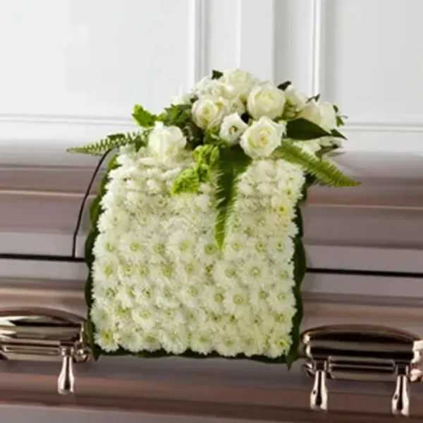 White floral casket spray with roses and chrysanthemums